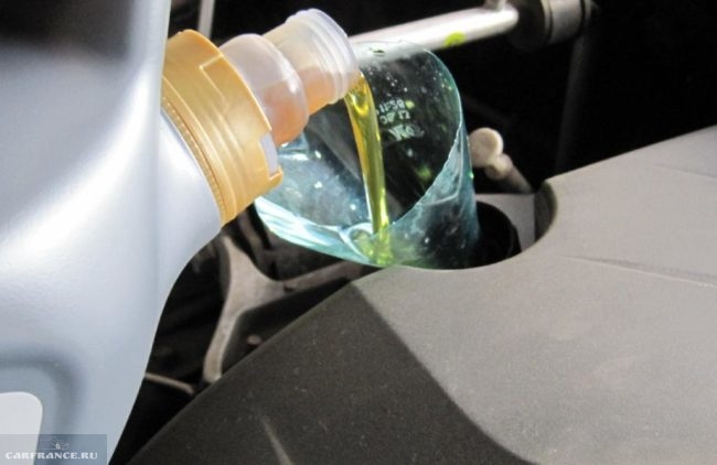 Заливка нового масла с помощью самодельной воронки из старой бутылки в двигатель седана Митсубиси Лансер 9